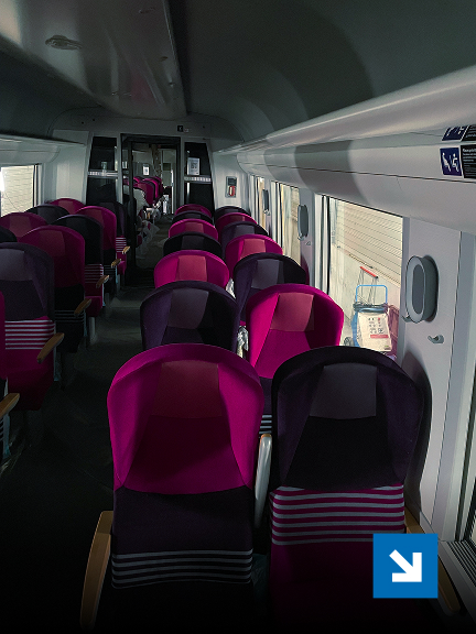 Intérieur d'un train avec sièges roses.